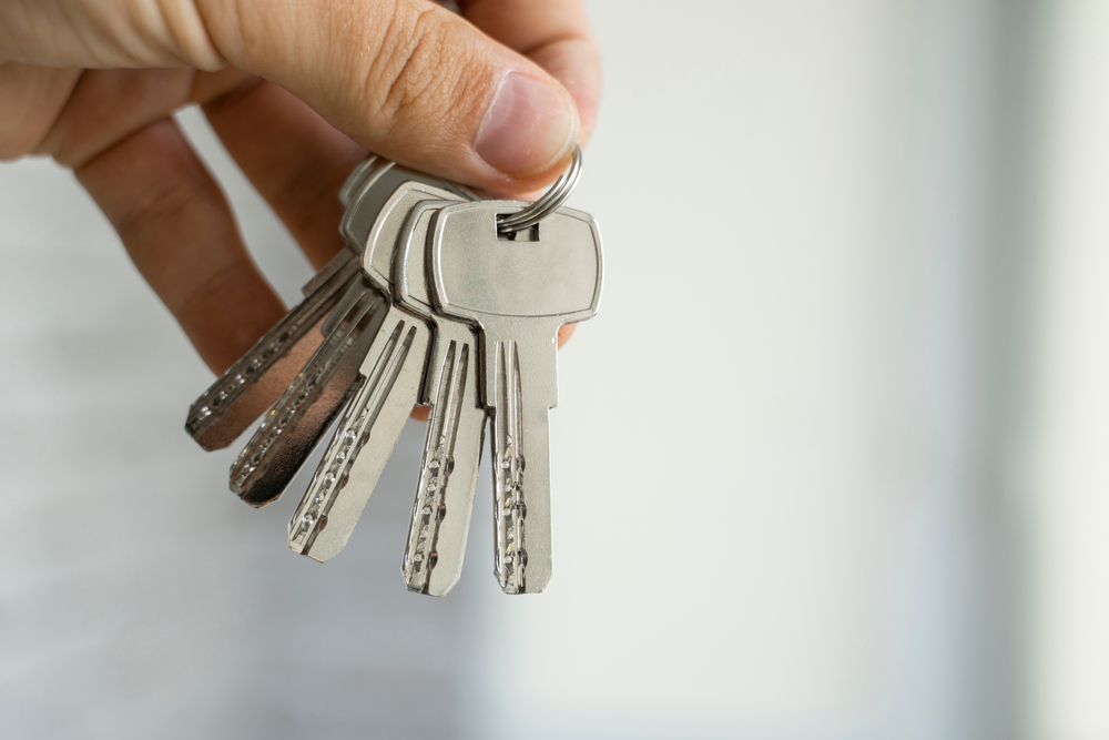mens,hand,holding,a,set,of,keys.,realtor,is,giving