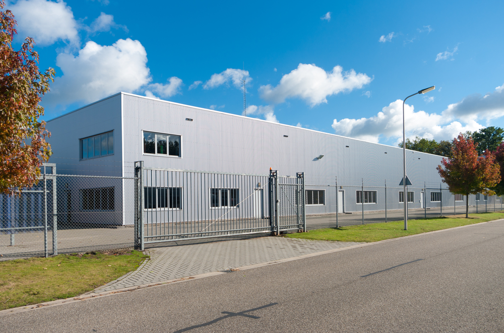 modern,exterior,of,an,industrial,building,,surrounded,by,a,fence