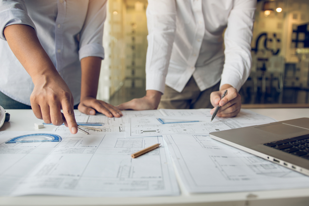 engineers,are,helping,to,design,work,on,blueprints,and,collaborate