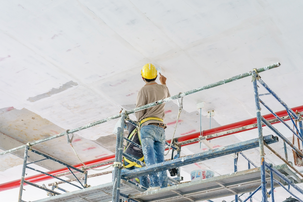 construction,workers,on,scaffolding,tower,painting,and,renovating,building,floor